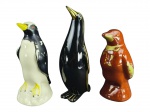 ESCULTURAS, lote com três (3) esculturas representando pinguins de modelos, tamanhos e decorações distintas confeccionados em faiança, 2 apresentam falhas na pintura, maior medindo 28cm e menor 21cm.