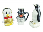 ESCULTURAS, lote com três (3) peças, sendo 2 esculturas e 1 caneca representando pinguins de modelos, tamanhos e decorações distinta, confeccionados em porcelana, apresentam falhas na pintura, maior medindo 20cm e menor 15,5cm.