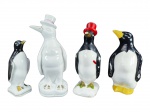 ESCULTURAS, lote com quatro (4) esculturas representando pinguins de modelos, tamanhos e decorações distinta, 2 confeccionados em porcelana branca e 2 em faiança, apresentam falhas na pintura, maior medindo 25cm e menor 17cm. 1 bicado.