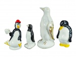 ESCULTURAS, lote com quatro (4) esculturas representando pinguins de modelos, tamanhos e decorações distinta, 3 confeccionados em porcelana branca e 1 em faiança, apresentam falhas na pintura, maior medindo 23,5cm e menor 14cm. Menor bicado na base.