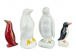 ESCULTURAS, lote com quatro (4) esculturas representando pinguins de modelos, tamanhos e decorações distinta, 1 confeccionados em porcelana branca e 3 em faiança, apresentam falhas na pintura, maior medindo 24cm e menor 15cm.