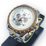 RELÓGIO, um (1) relógio de pulso com caixa e pulseira em aço bicolor, aro estilizado com mostrador prateado com submostradores expondo o maquinário, pulseira com ausência da trava e pinos adptados, possivelmente se trata de uma réplica, pequeno arremate do mostrador solto, não testado e sem garantia de funcionamento, ponteiro de minutos preso no mostrador, caixa medindo 5,5cm.