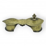 BRONZE, uma (1) paduka tradicional hindu, confeccionada em bronze, com estrutura dupla, recortes ornamentais, gravações geométricas e pino de apoio para os dedos. Peça de caráter religioso, medindo 4,5x12,5x5,5cm.