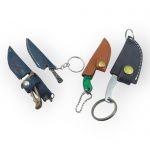 COLECIONISMO, quatro (4) miniaturas de facas e canivetes tipo chaveiro, em metal, com cabos variados, acompanhadas de respectivas bainhas em couro e couro sintético, argolas e correntes metálicas, maior medindo 11cm e menor 8cm.
