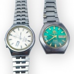 RELÓGIOS, dois (2) relógios de pulso masculinos da marca Orient, sendo: A) 1 automático, mostrador claro com marcadores aplicados, calendário duplo para dia da semana e data, caixa e pulseira em aço, mostrador torto e pulseira arrebentada, no estado, funcionando, sem garantias futuras e visor trincado, medindo 4cm e B) 1 automático, 21 rubis, mostrador verde com marcadores dourados, calendário duplo para dia da semana e data, caixa e pulseira em aço arrebentada, sinais de uso, funcionando, sem garantias futuras, caixa medindo 4cm.