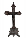 ARTE SACRA, um (1) crucifixo de mesa confeccionado em bronze, cruz ricamente cinzelada por elementos vegetalistas e geométricos em recortes, apoiado sobre base quadrangular com pés finalizados em garra, medindo 32x18cm.
