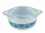 PYREX AMERICANO, um (1) pequeno pirex redondo com tampa confeccionado em vidro opalinado na tonalidade branca, decorado por guirlanda vegetalista na tonalidade azul, medindo 8x20x16cm.
