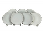 Edelstein (Bavaria), sete (7) pratos rasos, confeccionados em porcelana alemã na tonalidade branca com borda em ouro, alguns com levíssimas falhas na douração, medindo 26cm de diâmetro.