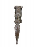 BRONZE, uma (1) aldrava confeccionada em bronze representando figura feminina, apoiada sobre base com cinzelado e recortes na borda, medindo 18,5cm de comprimento.