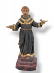 ARTE SACRA, um (1) imaginário confeccionado em madeira entalhada a mão representando São Francisco de Assis com patina policromada e realces em douração, apoiada sobre base escalonada em tom vermelho e preto, medindo 27,5cm.