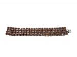 BIJUTERIA, uma (1) pulseira confeccionada em strass de metal prateado com incrustação de cristais na tonalidade âmbar com lapidação em facetas, fecho tipo gaveta, medindo 18cm.