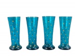 VIDROS, quatro (4) copinhos para licor confeccionados em vidro na tonalidade azul com decoração perolada com vestígios de douração, 1 apresenta bicado, medindo 8x3cm.