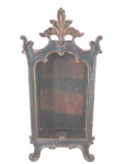 ARTE SACRA, um (1) oratório confeccionado em madeira escura e entalhada por elementos vegetalistas, patina escura com bordas realçadas em dourada, apresenta fissura na parte traseira, medindo 42x19,5cm.