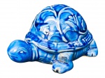 ESCULTURA, uma (1) escultura confeccionada em faiança vitrificada na tonalidade azul representando tartaruga, decorada por elementos vegetalistas em relevo na pasta e selo HOME STYLE, apresenta sinais de craquele, medindo 10x18x12,5cm.