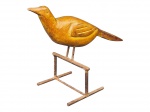 ESCULTURA, uma (1) escultura representando pássaro confeccionada em madeira entalhada a mão com base em ferro com sinais de oxidação, medindo 22,5x32x14cm.