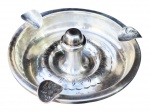METAL PRATEADO, um (1) cinzeiro confeccionado em metal espessurado a prata, formato circular, cinzelado em pontilhados com pega central torneada, medindo 4,5x13cm.