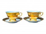 PORCELANAS, duas (2) xícaras de coleção para chá com seus respectivos pires confeccionadas em porcelana na tonalidade branca com vasta douração, decorada por elementos vegetalistas, interior em degradê na tonalidade azul e pínturas de cena galantes distintas em policromia, medindo 7x11,5x9,5cm.