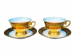 PORCELANAS, duas (2) xícaras de coleção para chá com seus respectivos pires confeccionadas em porcelana na tonalidade branca com vasta douração, decorada por elementos vegetalistas, interior em degradê na tonalidade azul e pínturas de cena galantes distintas em policromia, medindo 7x11,5x9,5cm.