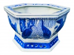 PORCELANA ORIENTAL, um (1) cachepot sextavado confeccionado em porcelana na tonalidade branca, decorado por codornas, elementos florais, vegetalistas e geométricos na técnica BLUE AND WHITE, base com vazados e furo ao centro para escapamento de água, medindo 18x30x26,5cm.