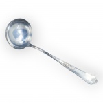 HERCULES INOX, uma (1) concha confeccionada em aço inox com cabo cinzelado por elementos vegetalistas finalizado por concheado, apresenta falhas na prateação, possivelmente levou banho de prata.