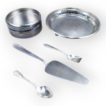 METAL PRATEADO, lote com cinco (5) peças confeccionadas em metal espessurado a prata, sendo: A) 1 porta garrafas BEL PRATA com suporte para tampa quebrado e ausência da mesma, medindo 5x11,5cm, B) 1 salva circular com galeria vazada e pés em bola, medindo 18cm, C) 1 pá  para bolo em aço inox Meridional, D) 1 colher para café CHRISTOFLE, gravado ALEIDE e E) 1 colher para açúcar.