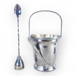 METAL PRATEADO, lote com três (3) peças confeccionadas em metal espessurado a prata, sendo: A) 1 balde de gelo da manufatura REGIA, cinzelado por elementos vegetalistas, medindo 25x14cm, B) 1 pegador de gelo da manufatura EBERLE, finalizado em garras, medindo 16cm e C) 1 colher bailarina com dosador com cabo torcido da manufatura AUREA, medindo 26,5cm.