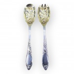 METAL INGLÊS, dois (2) talheres para salada, sendo: A) 1 colher e B) 1 garfo, confeccionados em metal espessurado a prata da manufatura OLD ENGLISH, cabo cinzelado por elementos vegetalistas e parte superior com frutos e folhagens relevados e esmaltados em verméil.