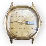 RELÓGIO, um (1) relógio de pulso da manufatura MONDAINE, modelo automático, caixa retangular com laterais curvas, mostrador dourado com calendário, ausência da pulseira e ranhuras na caixa, porém, funcionando, sem garantias futuras, medindo 3x3cm.