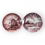 FAIANÇAS, dois (2) pratos decorativos confeccionados em faiança vitrificada, ambos decorados por vistas do Pão de Açúcar no Rio de Janeiro em tonalidade avermelhada, ambos com leves falhas, medindo 26 e 27cm de diâmetro.