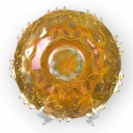 CARNIVAL GLASS, um (1) prato para bolo confeccionado em vidro artístico na tonalidade fogo, moldado por elementos vegetalistas, geométricos e bico de jaca com ondulações na borda, apresentando falhas na esmaltagem ao centro, medindo 31,5cm de diâmetro.