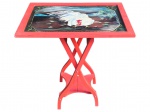 MOBILIARIO, uma (1) mesa dobrável em madeira, modelo apoio/serviço, com tampo retangular e estrutura articulada (fechamento tipo sanfona), acabamento na cor vermelha e tampo decorado com pintura manual representando galo branco, com filetes ornamentais nas bordas, medindo 89x56,5x41,5cm, apresenta falhas no tampo.