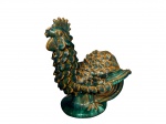 <b>ESCULTURA</b>, uma (1) escultura representando galo confeccionado em cerâmica vitrificada nas tonalidades verde e ocre, corpo revestido por relevos escamados e base circular, estilo de produções caldenses do início a meados do século XX, apresentando bicados, vide foto, medindo 17x15x13cm.