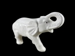 ESCULTURA, uma (1) escultura confeccionada em faiança vitrificada na tonalidade branca representando elefante, olhos com apliques de pedras sintéticas, leves bicados, medindo 18,5x33cm.