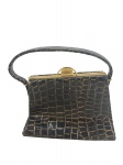 ACESSÓRIO FEMININO, uma (1) bolsa vintage da manufatura TENRIS, confeccionada em couro na tonalidade preta com realces em dourado, guarnições em metal dourado, interior acetinado na tonalidade preta, sinais de oxidação, medindo 17x22,5cm, leves falhas no couro.