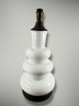 ABAJUR, um (1) abajur para uma lâmpada confeccionado em faiança vitrificada na tonalidade branca, corpo torneado em gomos e base circular em metal dourado, apresenta sinais de craquele e fiação antiga, medindo 50cm de altura.