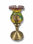 ABAJUR, um (1) abajur para uma lâmpada confeccionado em metal dourado, base cônica e escalonada, corpo torneado, cúpula em vidro artístico em policromia com realces preto em relevo, medindo 28,5cm de altura, fiação nova.