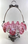 OPALINA DE SÉVRES - CENTRO DE MESA EM OPALINA DE SÈVRES EM TOM ROSADO E BRANCO COM BELÍSSIMO EFEITO DEGRADÊ E BORDAS PLISSADAS , REPOUSA SOBRE UMA ARMAÇÃO EM METAL PRATEADO RICAMENTE TRABALHADO, BASE CIRCULAR EEVA-SE SOBRE PÉS DECORADOS COM MOTIVOS FLORAIS  E RELEVOS ESTILIZADOS, ALÇA SUPERIOR EM ARCO ACIMADA POR ELEGANTE MEDALHAO CIRCULAR LADEADO POR RAMOS DE LOURO EM ESTILO NEOCLÁSSICO. MEDIDAS: 43 x 30 cm