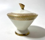 Pequeno pote com tampa em porcelana alemã na cor creme com decoração em dourado. Medidas: 9 cm de alt.