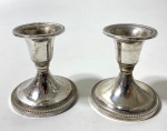 Par de pequenos castiçais em metal prateado. Medidas: 6,5 x 4 cm