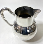 Jarra em metal prateado, bom banho. Medidas: 18, 5 cm de altura. com pontos de amassados