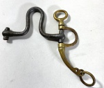 EBERLE- ANTIGA HASTE LATERAL (PERNA) DE FREIO DE GALA OU MILITAR, CONFECCIONADA EM ESTRUTURA BIOMETÁLICA, FERRO FORJADO E LATÃO FUNDIDO, EXCELENTE PEÇA DE REPOSIÇÃO PARA COLECIONADORES DE MILITARIA, ARREIOS HISTÓRICOS OU PARA EXPOSIÇÃO DECORATIVA. MEDIDAS: 17 X 16 CM