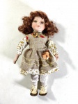 BONECA  DE COLEÇÃO DE LOUÇA OU PORCELANA CORPO EM TECIDO ESTRUTURADO E ENCHIMENTO FLEXÍVEL FALTA UM CÍLIO MEDIDAS: 30 CM