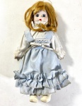 BONECA  DE COLEÇÃO DE LOUÇA OU PORCELANA CORPO EM TECIDO ESTRUTURADO E ENCHIMENTO FLEXÍVEL . MEDIDAS: 27 CM