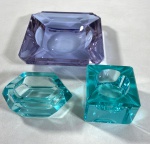 MOSER - TRÊS CINZEIROS EM CRISTAL COLORIDO. APRESENTA BICADOS. MEDIDAS: MAIOR  3 X 14 X 14 CM / MENOR 4 X 9 X 5,50 CM