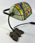 PEQUENA LUMINÁRIA DE MESA ESTILO TIFFANY COM MOTIVO DE BORBOLETA, BASE EM METAL FUNDIDO ESCULPIDO NA FORMA DE BORBOLETA COM ASAS ESTENDIDAS. MEDIDAS: 26 X 15 X 19 CM