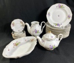 CONJUNTO EM PORCELANA NACIONAL MAUÁ FUNDO BRANCO COM DECORAÇÃO FLORAL E DETALHES EM DOURADO COMPOSTO POR: 11 PRATOS FUNDOS BULE PARA CAFÉ SEM TAMPA, BULE PARA CHÁ COM TAMPA, TRAVESSA OVAL, 7 PIRES. APRESENTA BICADO EM 1 PIRES, 1 PRATO FUNDO E  TAMPA. APRESENTA PADRONAGENS DE COR  NA TRAVESSA E PIRES. MEDIDAS: TRAVESSA 5 X 21 X 30 CM / PRATO FUNDO 23 CM