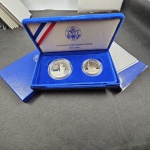 EUA, estojo de luxo com as moedas de Half Dollar e de 1 Dollar (esta em prata), PROOF, 1986, comemorativas dos 100 anos das Liberty Coins. Imperdível! Acompanham certificados