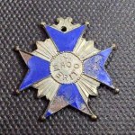 Brasil, antiga comenda/insígnia honorífica militar em formato de estrela radiada de pontas bipartidas, confeccionada em metal com banho prateado e esmalte azul. Centralizado no anverso, medaglion circular com a legenda "AO MÉRITO" encimada por estrela. Coroa superior articulada/vazada com orifício para fita suspensora. Reverso liso. Peça com pátina e pequenas perdas parciais no esmalte causadas pelo tempo, mantendo excelente apelo histórico.