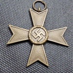 Alemanha (II Guerra Mundial), Medalha original, Cruz de Mérito de Guerra de 2ª Classe sem Espadas (Kriegsverdienstkreuz 2. Klasse ohne Schwerter), instituída em 1939. Confeccionada em bronze/liga metálica, em formato de cruz de Malta com textura granulada nos braços. Anverso ostentando medalhão central circundado por coroa de carvalho com a suástica. Reverso trazendo o ano de instituição "1939" no medalhão central. Acompanha anel de suspensão original. Item de relevante apelo histórico e militar. OBS: O item não Promove ou glorifica a violência da intolerância racial ou religiosa. Está à venda apenas para fins de preservação da memória histórica. A Casa de Leilões não faz apologia a quaisquer movimentos políticos ou ideológicos, bem como repudia qualquer ideologia de cunho racista.