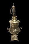 Rússia - Antigo samovar confeccionado em metal espessurado a prata com belíssimo trabalho cinzelado com motivação persa ;pegas torneadas em metal prateado com fino acabamento e pés em forma de garras, circa de 1930, medidas: 86 x 37 x 39 cm.